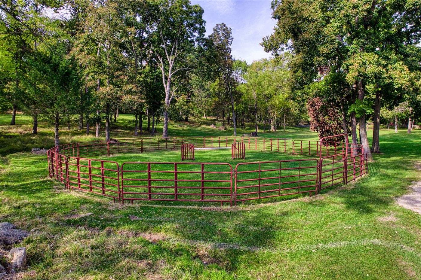 Red pipe round pen under shade trees